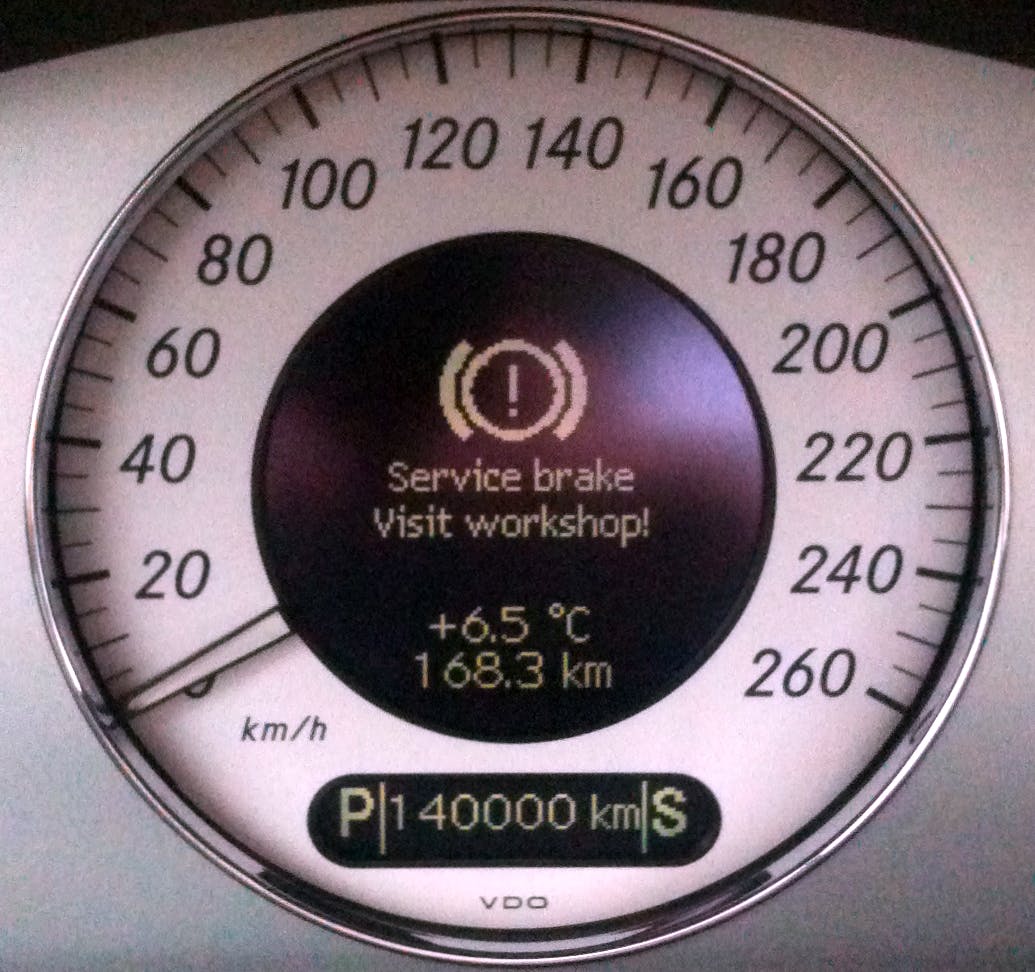 Picture of dashboard in Mercedes W211 displaying the "Service brake Visit workshop!" warning message.